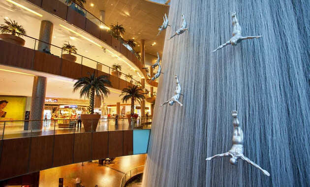 a water fall with statues in mall of dubai